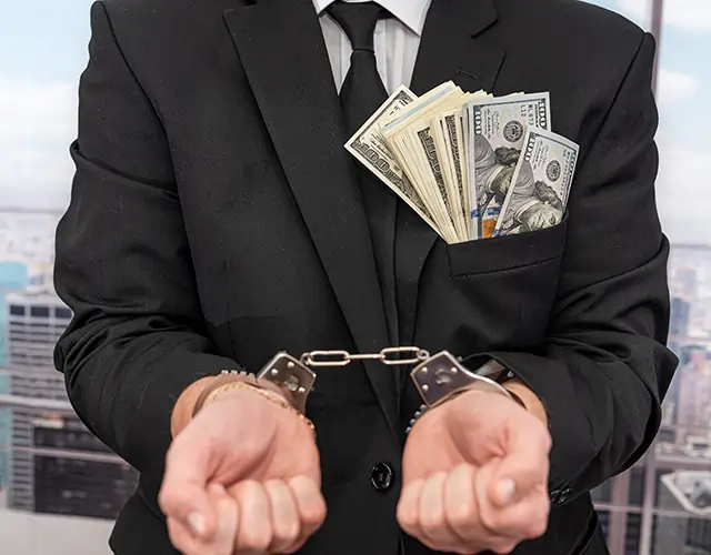 Man with pocket full of money in handcuffs